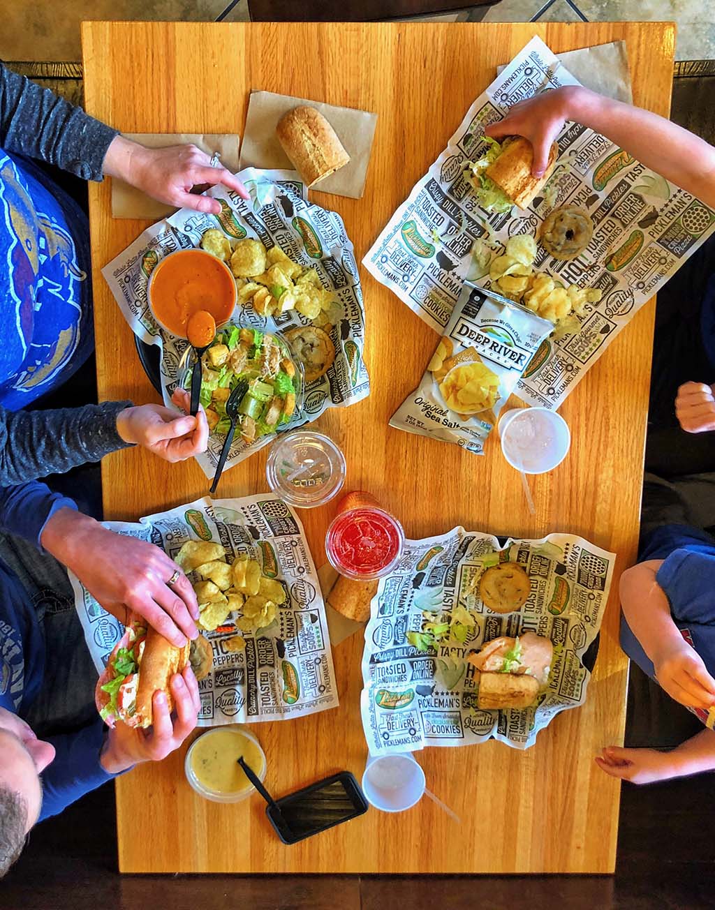 IMG_3928 An overhead view of four people eating inside a Pickleman's